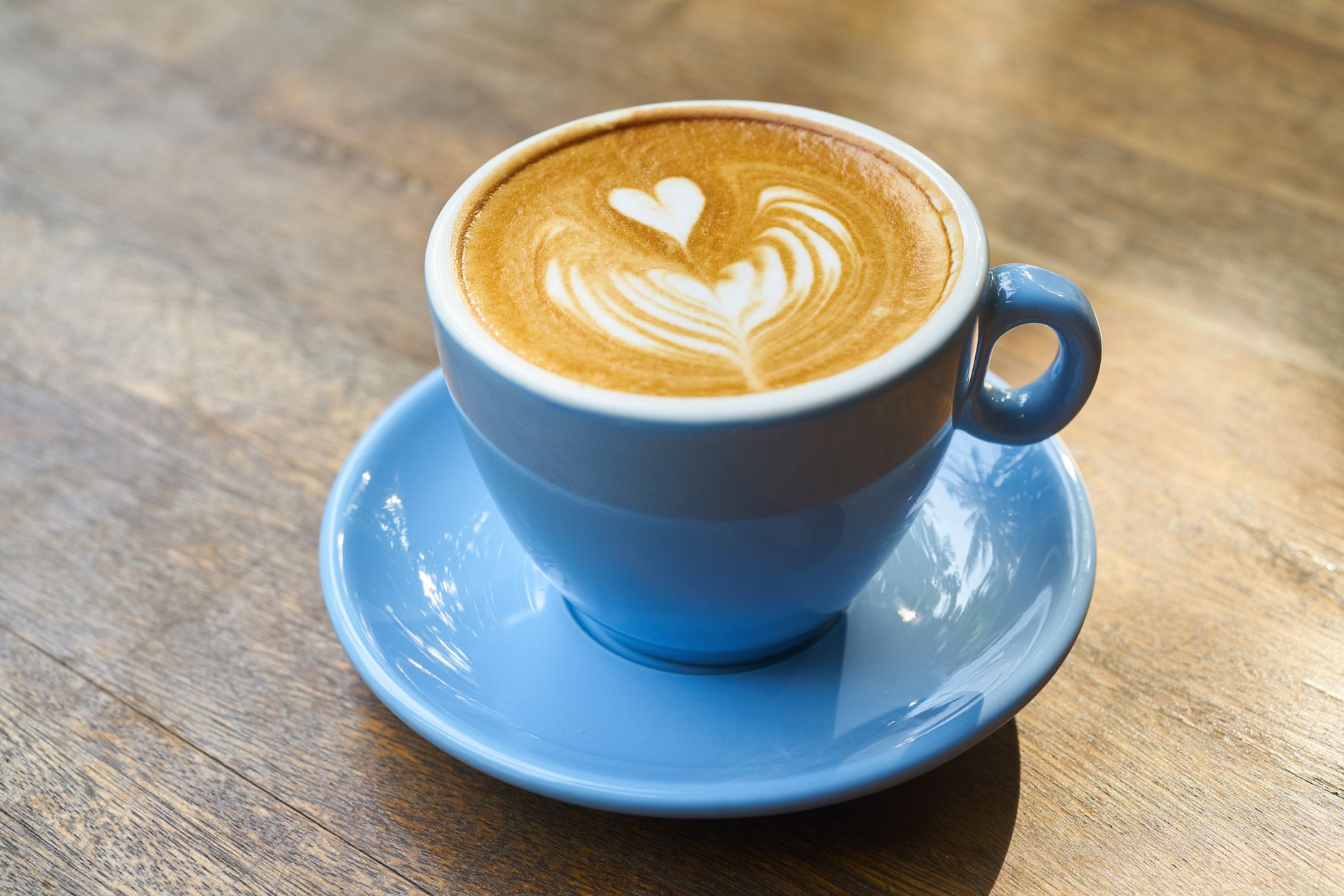 木のテーブルに置かれたコーヒーカップ