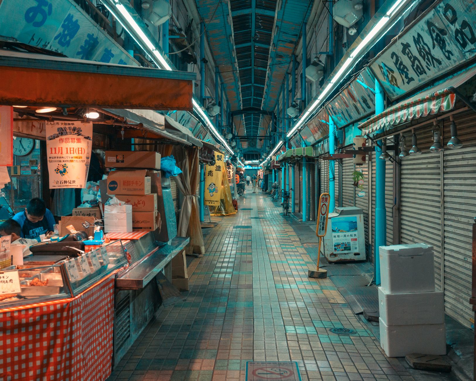 夜の商店街のアーケードと灯りのともる店先