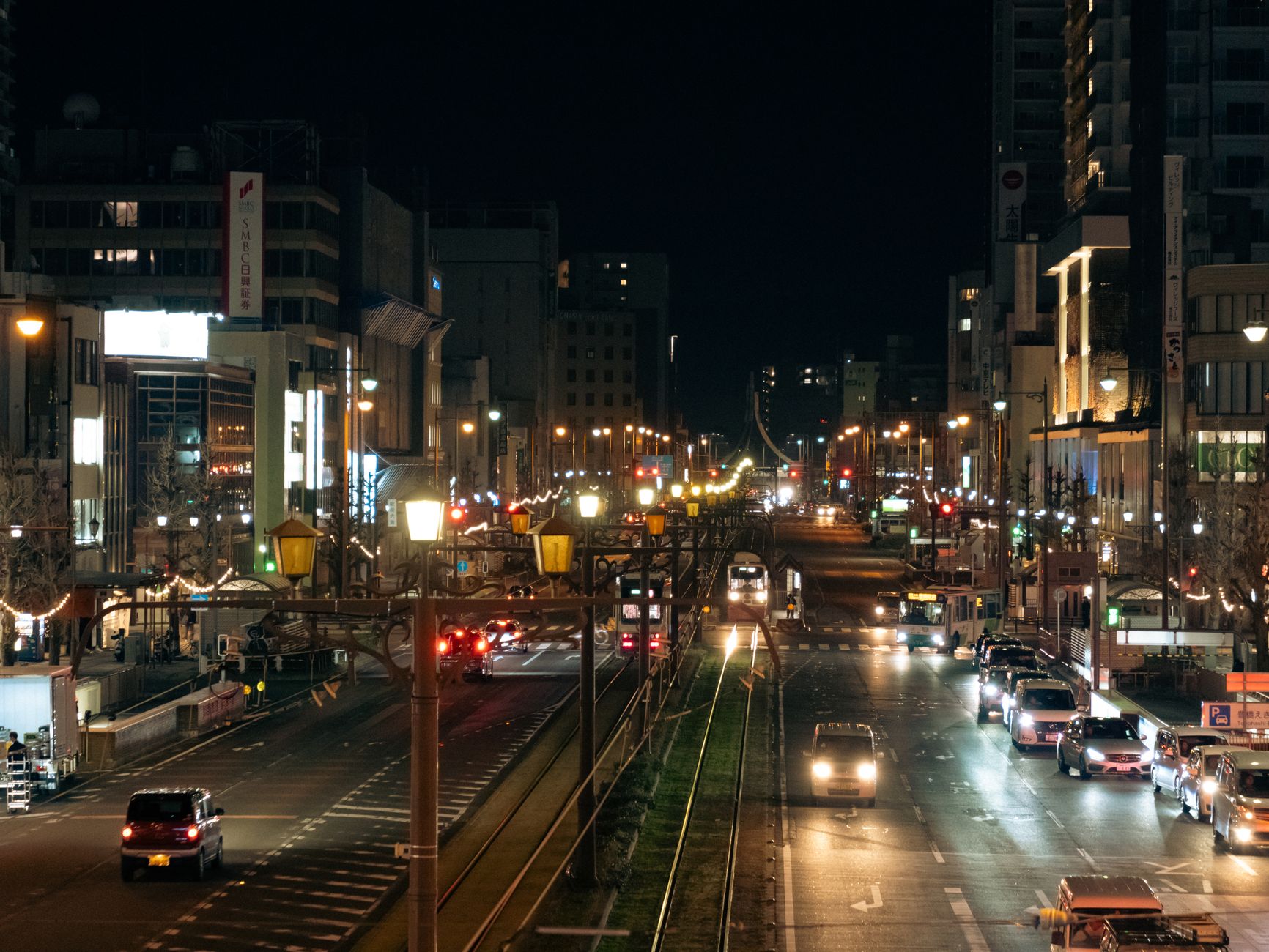 夜の街のビル群と灯りのともる看板