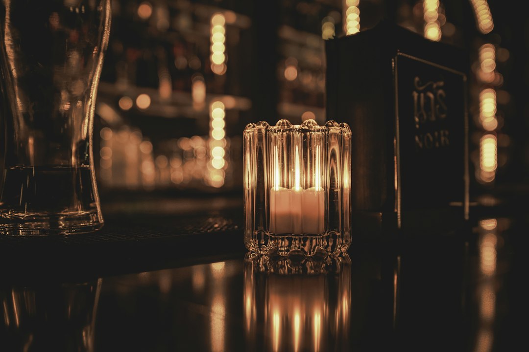 Candle lit in a glass holder on a bar counter