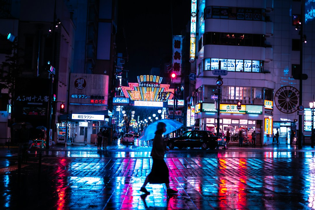 a woman walking down a street holding an umbrella