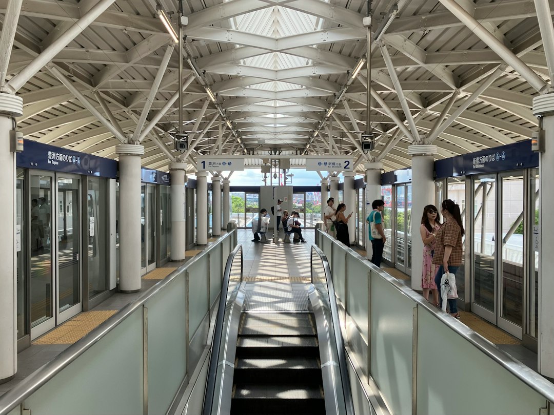 a group of people riding down an escalator in a train station