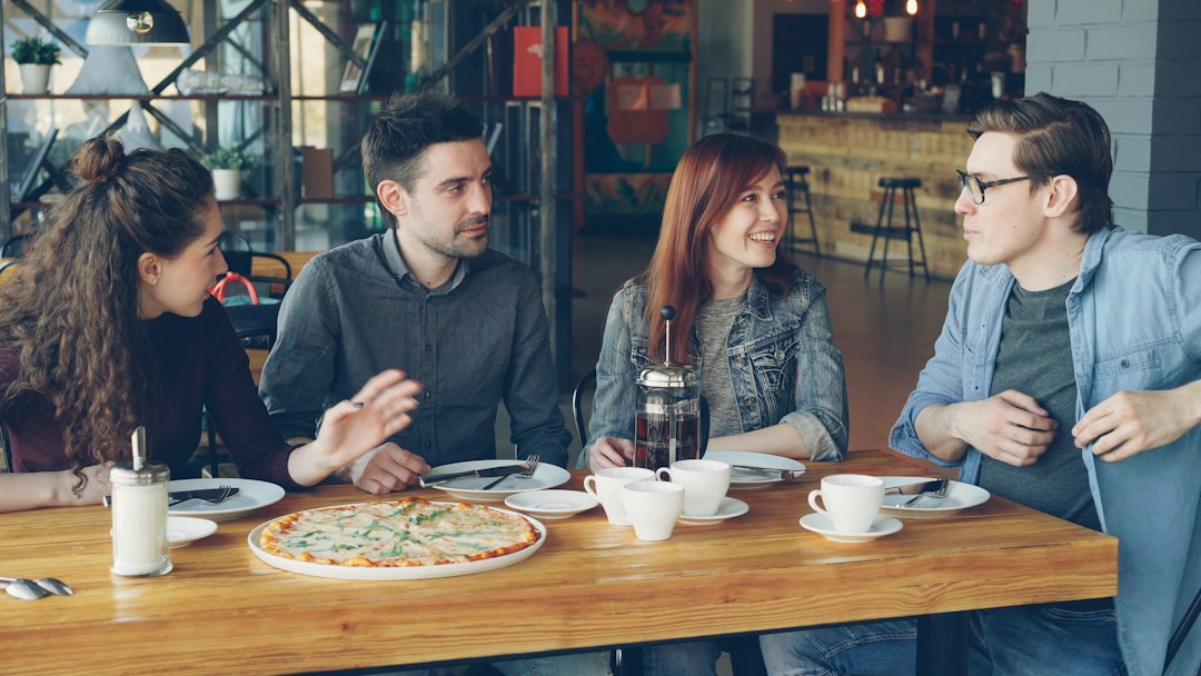 Friends are sharing pizza and conversation at a restaurant