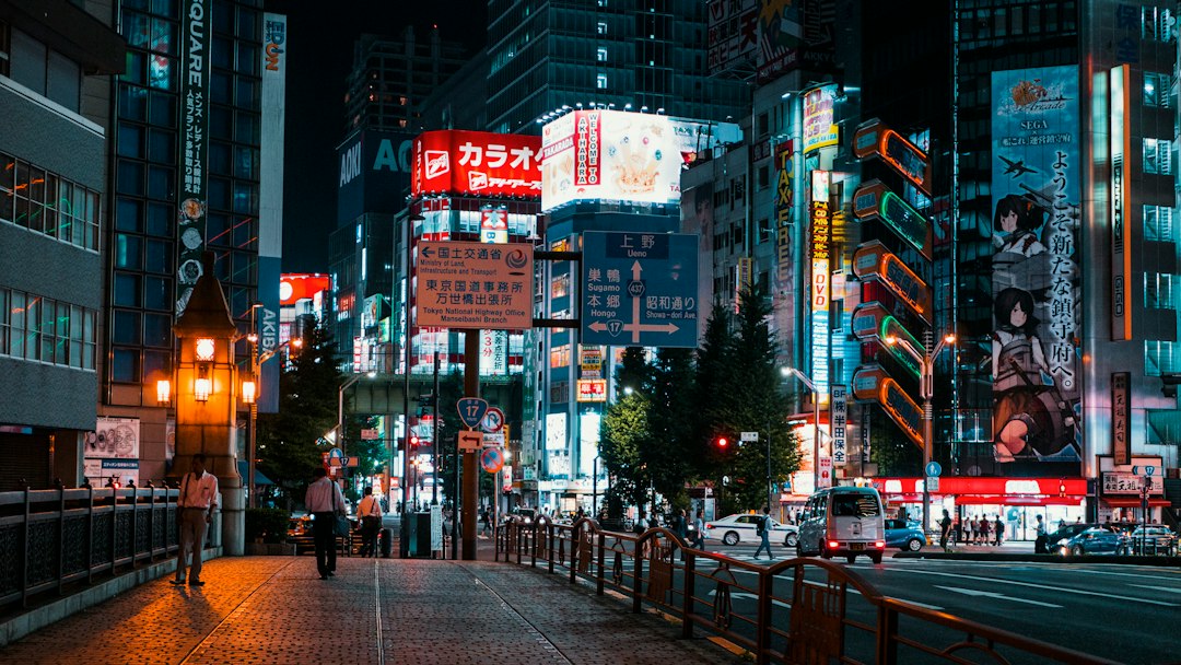 a city street at night with tall buildings