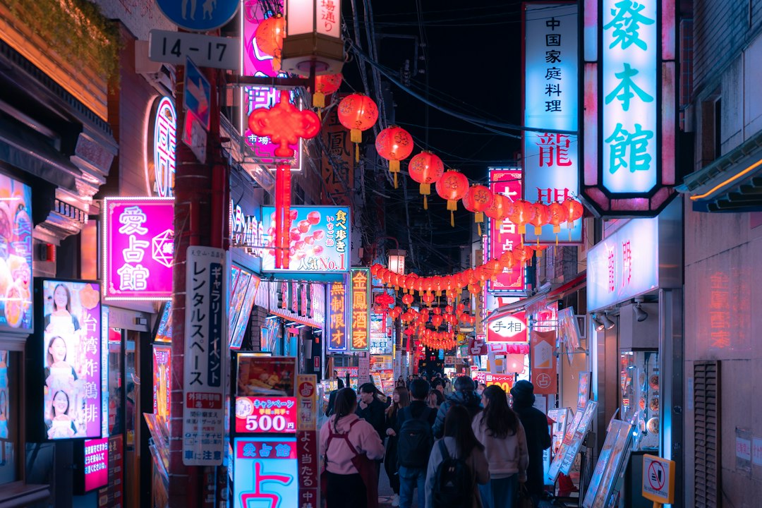 a group of people walking down a street at night